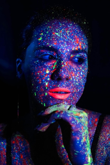 Linda garota sexy dança com tinta na televisão Garota com arte corporal neon em luz colorida