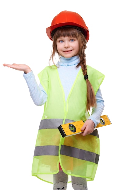 Linda garota sorridente com capacete protetor e colete de construção com medição de nível segura um anúncio de produto na palma da mão