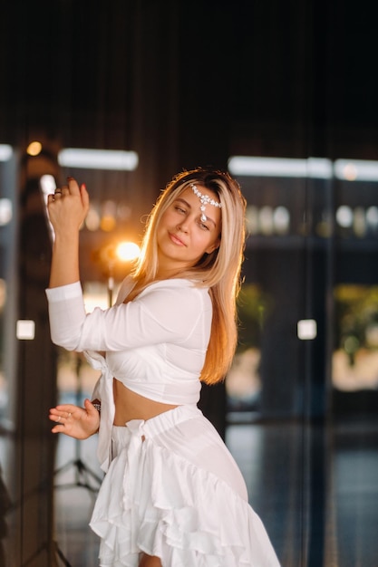 Linda garota sorridente em um vestido branco dançando no ginásio