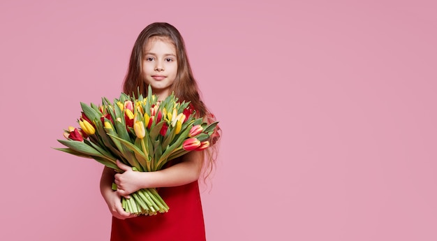 Linda garota sorridente segurando um buquê de flores da primavera