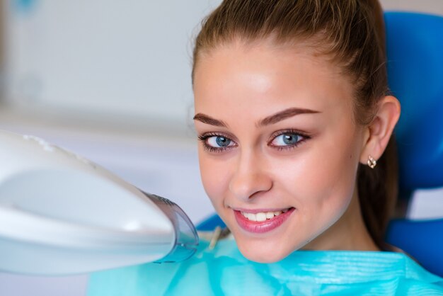 Linda garota sorrindo após o clareamento dental.