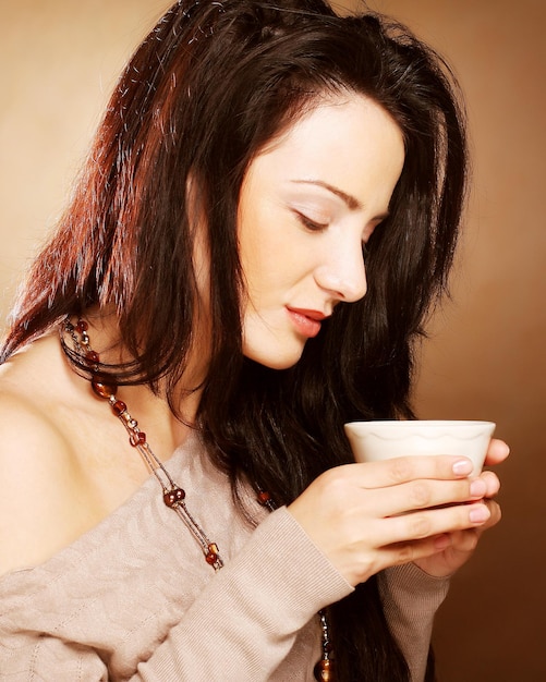 Linda garota tomando chá ou café