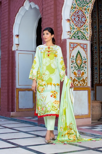 Linda garota totalmente vestida para sessão de fotos usando vestido floral moderno em lugar tradicional