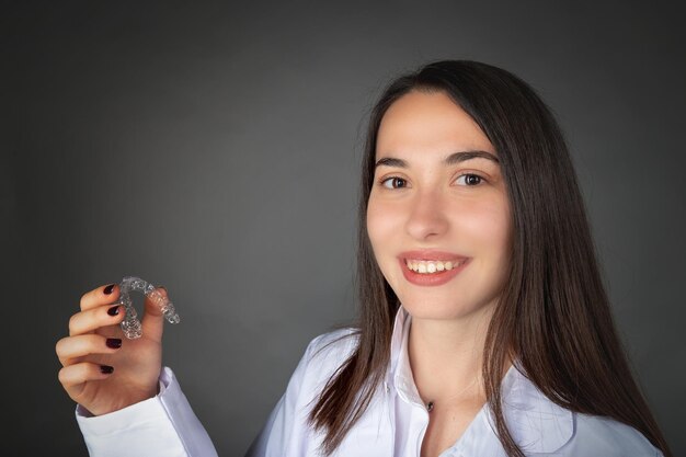 Linda garota turca sorridente mantendo invisaligner na mão