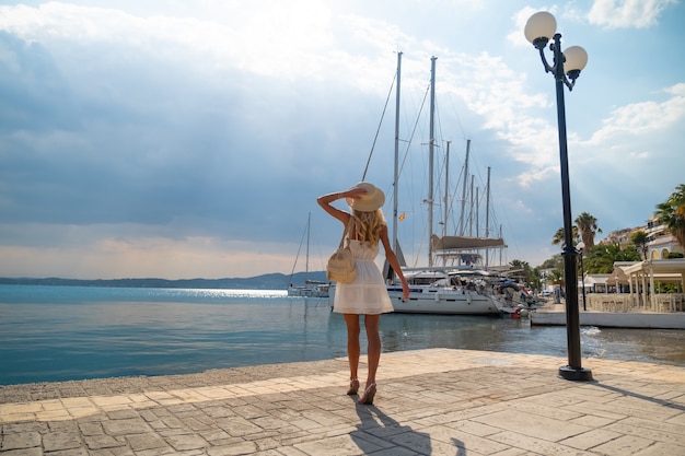 Linda garota turista caminhando no porto marítimo de ermioni marina na Grécia