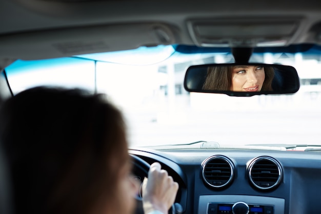 Linda garota vestindo camisa azul, sentado em um automóvel novo, preso no trânsito, retrato, comprando um carro novo, motorista de mulher.