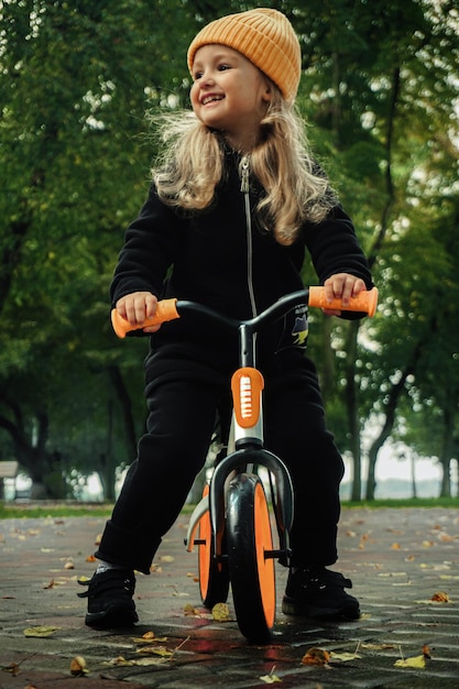 Linda garotinha anda de bicicleta no parque