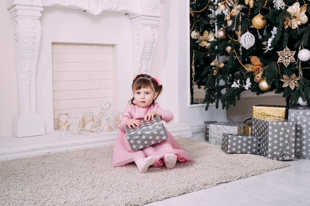 Linda garotinha brincando com um presente de natal