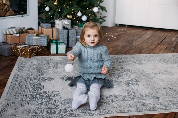 Linda garotinha brincando com uma decoração de Natal