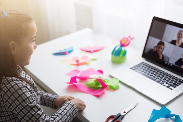 Foto linda garotinha cortando papel com uma tesoura na aula de arte. conceito de educação infantil. artesanato infantil. de volta à escola