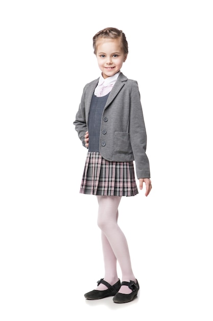 Linda garotinha em uniforme escolar isolado no branco
