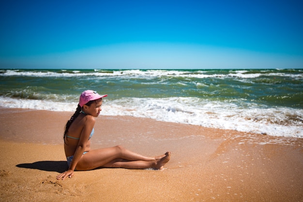 Linda garotinha feliz descansando na praia