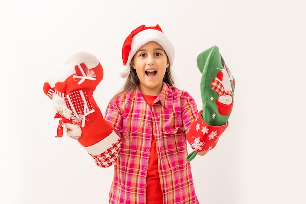 Linda garotinha sorridente em um vestido vermelho verificando sua meia de natal