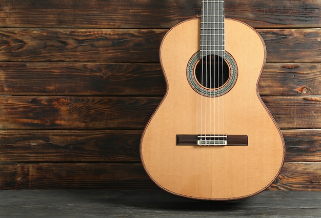 Linda guitarra clássica de seis cordas contra a mesa de madeira