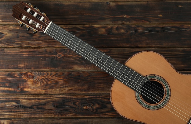 Linda guitarra clássica de seis cordas na mesa de madeira