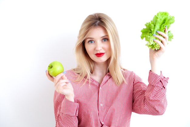 Linda hermosa dama con lápiz labial rojo con manzana y ensalada verde fresca