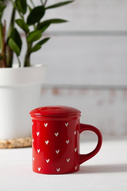 Una linda y hermosa taza roja con un estampado en forma de corazones blancos