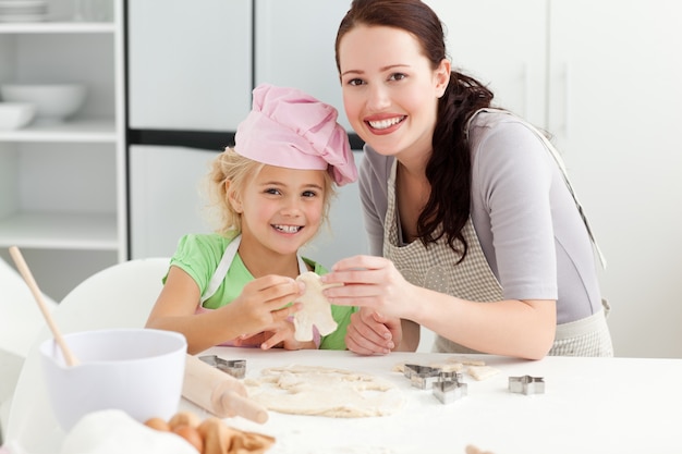 Linda hija y madre mostrando una galleta en forma de un hombre