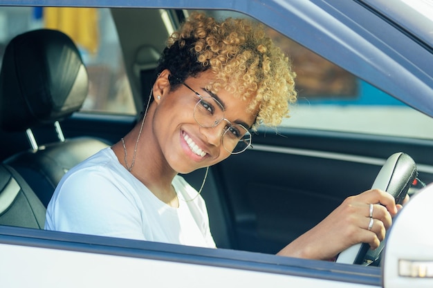 Linda jovem afro-americana multirracial dirigindo o primeiro carro