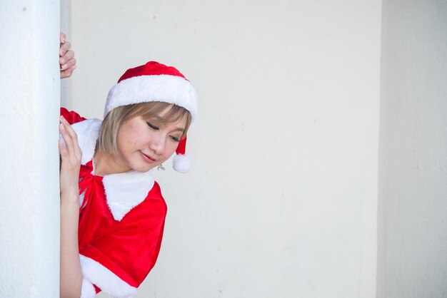 Linda jovem asiática com roupas de Papai Noel em fundo brancoPovo da TailândiaEnviado felicidade para criançasFeliz natalBem-vindo ao invernoFeliz conceito de mulher