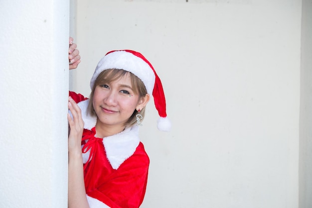 Linda jovem asiática com roupas de Papai Noel em fundo brancoPovo da TailândiaEnviado felicidade para criançasFeliz natalBem-vindo ao invernoFeliz conceito de mulher