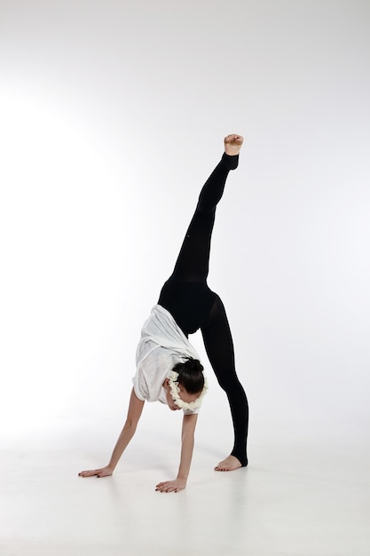 Linda jovem bailarina dançando em um fundo branco