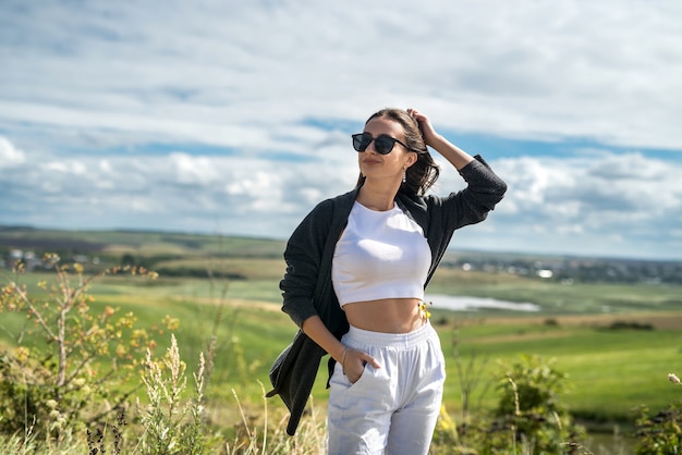 Linda jovem caminhando no campo e relaxe nas férias de verão. liberdade