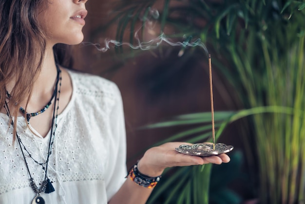 Foto linda jovem de atenção plena relaxando e desfrutando de incenso depois da aula de ioga