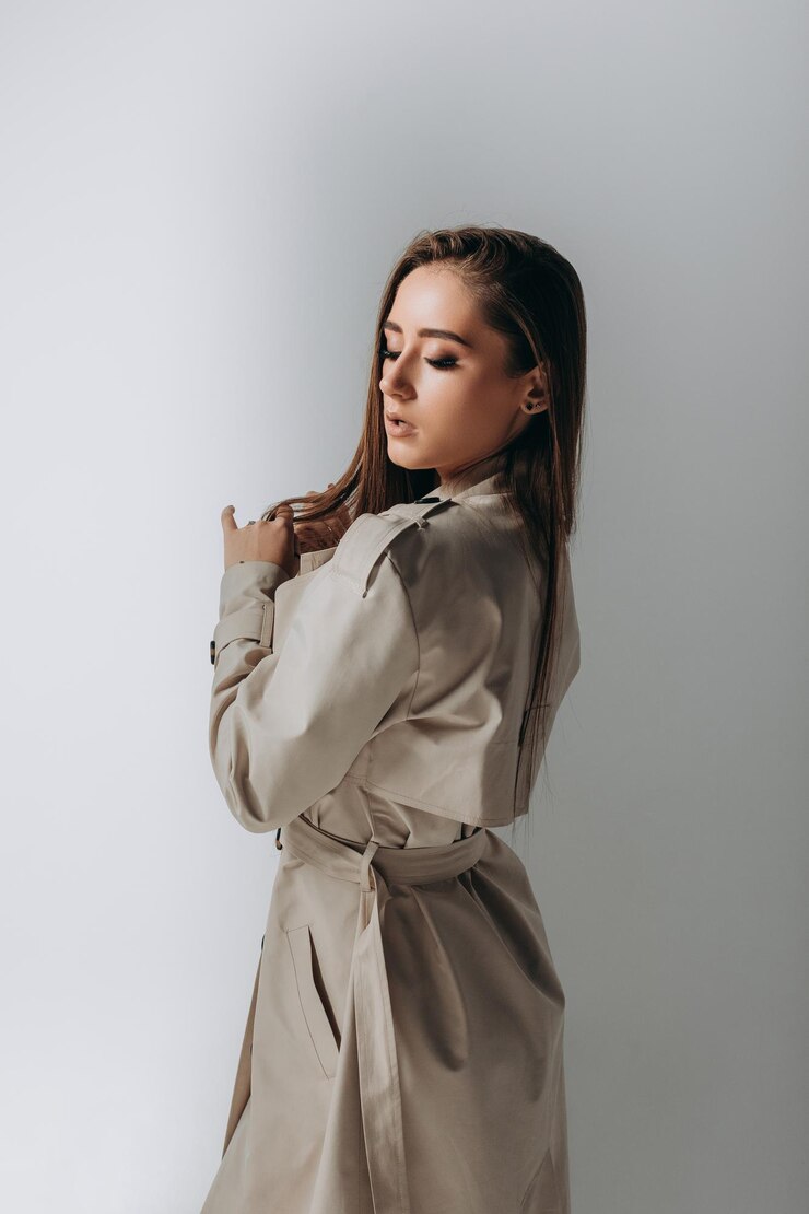 Linda jovem elegante de casaco no fundo branco