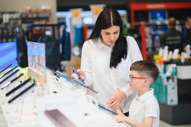 Linda jovem escolhendo qual smartphone comprar Compras na loja de tecnologia