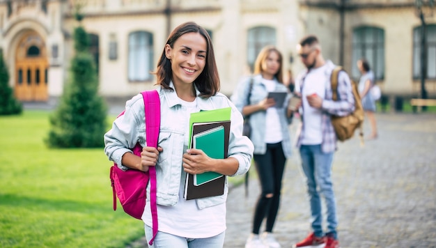 Linda jovem estudante com uma mochila e livros da universidade