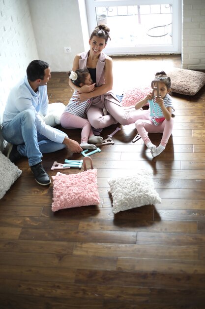 Foto linda jovem família com filhas em uma sessão de fotos em um estúdio branco