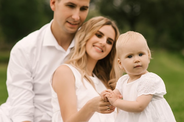 Linda jovem família mãe e pai com filha de um ano na natureza família feliz