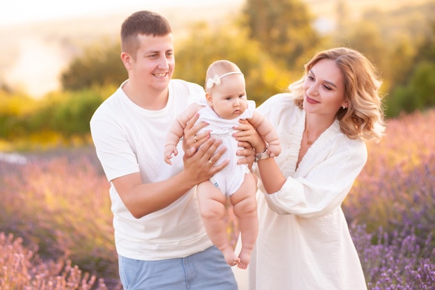 Linda jovem família, pai e mãe com bebê no campo de lavanda