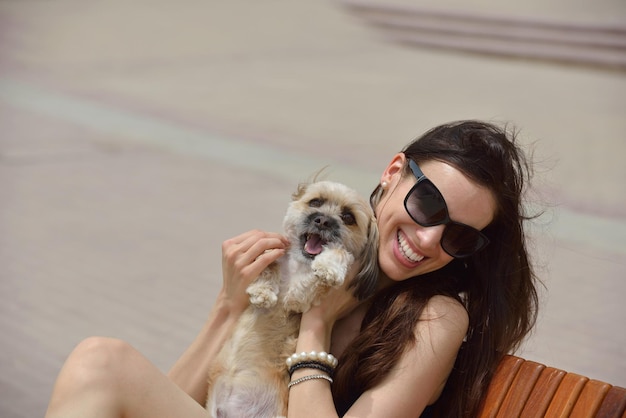 linda jovem feliz de vestido preto com cachorrinho fofo se divertir na rua