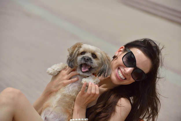 linda jovem feliz de vestido preto com cachorrinho fofo se divertir na rua