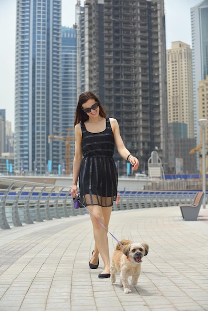 linda jovem feliz de vestido preto com cachorrinho fofo se divertir na rua