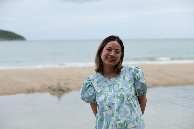 Linda jovem grávida andando na praia sente paz