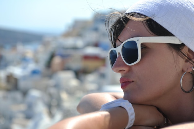 Linda jovem grega em roupas da moda se diverte nas ruas de Oia, Santorini, Grécia