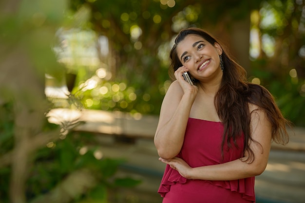 Linda jovem indiana feliz falando ao telefone no parque