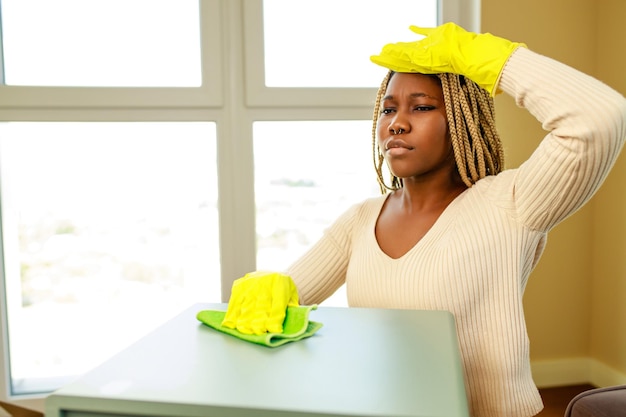 Linda jovem latino-americana em luvas de proteção limpando em casa