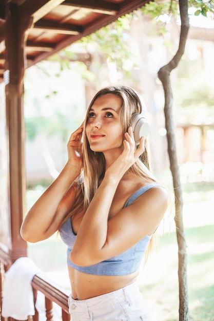 Linda jovem loira com fones de ouvido, ouvindo música