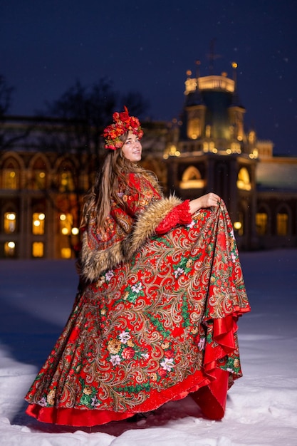 Linda jovem loira de cabelos compridos em roupas nacionais tradicionais russas no inverno