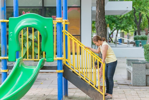 Foto linda jovem mãe brinca com sua filha se divertindo no playgroundfeliz dia das mãestailândia