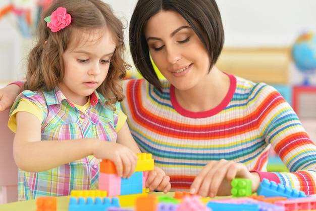 Linda jovem mãe brincando com sua filha pequena