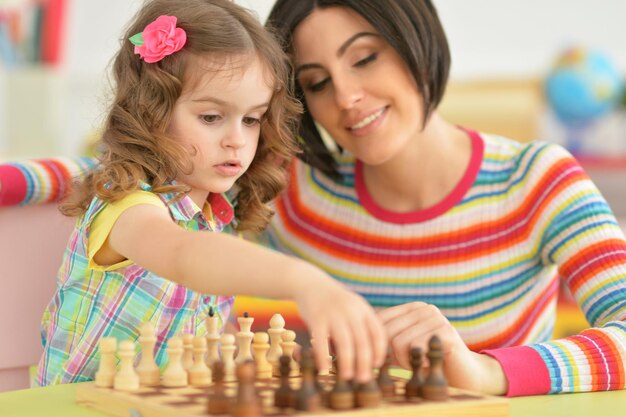 Linda jovem mãe brincando com sua filha pequena