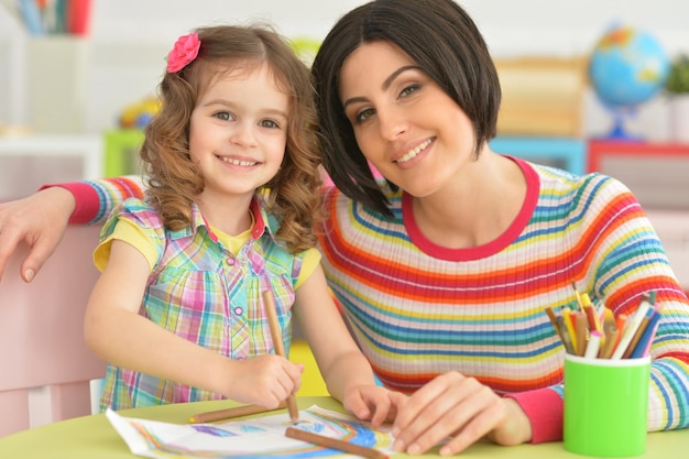 Linda jovem mãe brincando com sua filha pequena