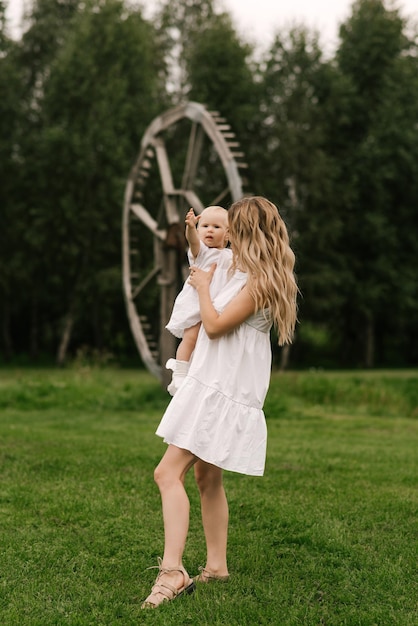 Linda jovem mãe com filha de um ano na natureza