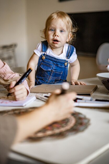 Linda jovem mãe e filha desenham um padrão de mandala juntos, marcadores artísticos e cores ...