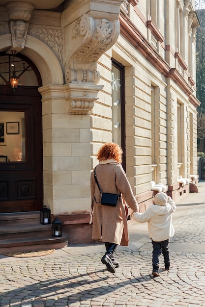 Linda jovem mãe e linda filha de 4 anos estão caminhando no centro da cidade velha Europa Família feliz